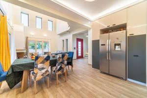 a kitchen and dining room with a table and a refrigerator at The Mountain Villa in Aleimmatádes