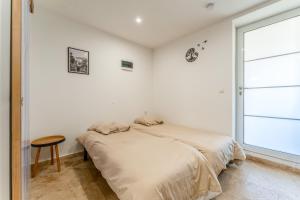 a white bedroom with a bed and a window at Canto Cigalo Rdc 1 in Robion en Luberon