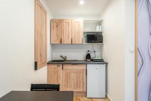 a small kitchen with wooden cabinets and a refrigerator at Canto Cigalo Rdc 1 in Robion en Luberon