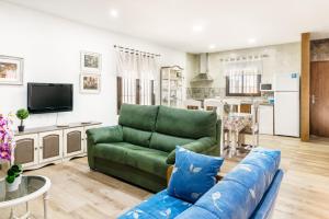 a living room with a green couch and a kitchen at Chalet Rubio Cabeza in Conil de la Frontera