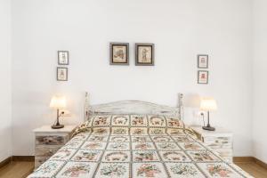 a white bedroom with a bed and two lamps at Chalet Rubio Cabeza in Conil de la Frontera +17 photos