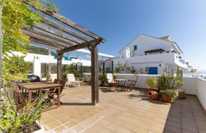 a patio with a wooden table and chairs at La Terraza del Mar in Manilva