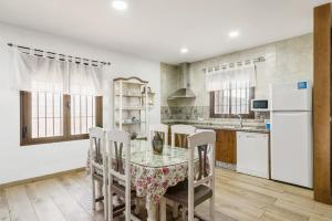 a kitchen with a table and chairs and a refrigerator at Chalet Rubio Cabeza in Conil de la Frontera