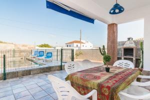 a patio with a table and chairs on a balcony at Chalet Rubio Cabeza in Conil de la Frontera