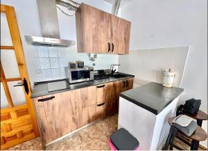 a kitchen with wooden cabinets and a microwave at Apartamento Rey Melchor in Trevélez