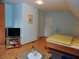 a small living room with a bed and a tv at Kuryhof in Simonswald