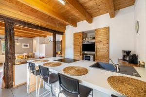 a kitchen with a large white counter with chairs around it at Ferienwohnung Rabus in Bisingen