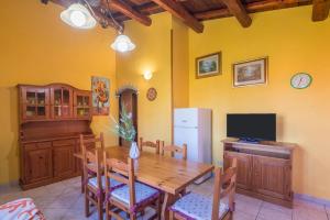 a kitchen with a wooden table and a refrigerator at Quadrilocale 800mt dal mare in San Teodoro