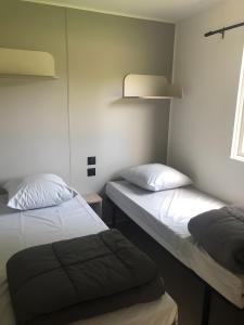 a room with two beds and a window at Mobilehome Riviera avec terrasse 47 in Saint-Gervais