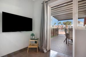 a living room with a flat screen tv on the wall at Place Oasis Green Luxury Pool in Maspalomas