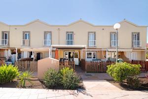an apartment building with a fence and plants at Place Oasis Green Luxury Pool in Maspalomas