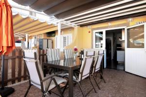 a dining room with a black table and white chairs at Place Oasis Green Luxury Pool in Maspalomas