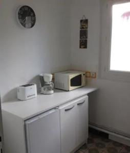 a microwave sitting on top of a kitchen counter at Apt T3 - 3 Min du Futuroscope in Chasseneuil-du-Poitou