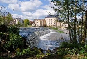 a river with a waterfall in a city at Apt T3 - 3 Min du Futuroscope in Chasseneuil-du-Poitou