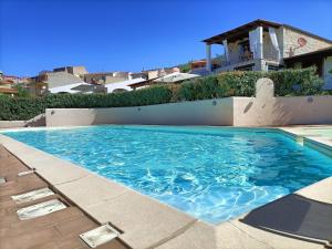 a swimming pool in front of a house at Villa Vigna in Badesi
