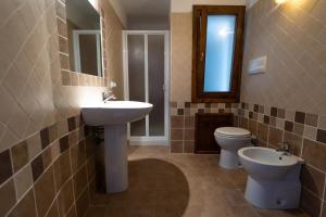 a bathroom with a sink and a toilet and a mirror at Villa Vigna in Badesi +25 photos