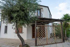 a house with a gate and a tree at Villa Vigna in Badesi