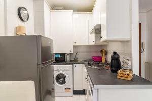 a kitchen with a refrigerator and a washing machine at Apartamento La Ribera in Suances