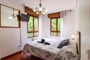 a bedroom with a bed and two windows at Apartamento La Ribera in Suances +21 photos