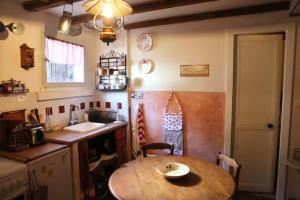 a kitchen with a wooden table and a sink and a table at Gite - Le befoigneu in Ferdrupt