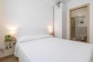 a white bedroom with a white bed and a bathroom at L'angolo Porto Torres in Porto Torres +46 photos