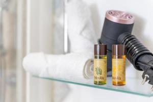 a shelf with two bottles of essential oils and a hair dryer at L'angolo Porto Torres in Porto Torres