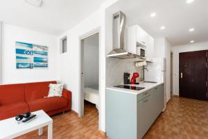 a kitchen and a living room with a red couch at Apartamento Lucía in Torre del Mar
