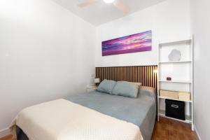 a bedroom with a bed and a painting on the wall at Apartamento Lucía in Torre del Mar +13 photos