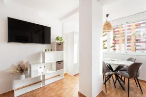 a white living room with a table and a tv at Apartamento Lucía in Torre del Mar