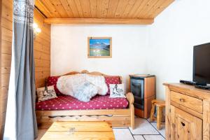 a living room with a couch and a tv at Savine in Val Cenis