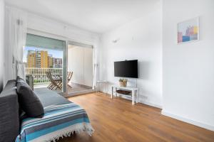 a bedroom with a bed and a tv and a window at Lopimar Bonito in Canet de Berenguer