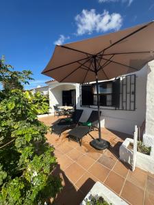 a patio with an umbrella and a table and chairs at Los Porches k29 in Playa del Ingles