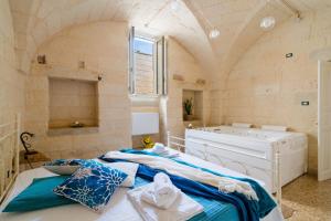 a bedroom with a large bed and a tub at Corte Cochlea La Curte Suite per 4 in Cannole