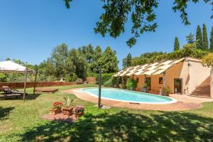 a backyard with a swimming pool and a house at Agriturismo Podere Marroneto in Monticiano