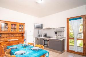 a dining room with a table and a kitchen at Sardegna Budoni giardino e Jacuzzi in Budoni