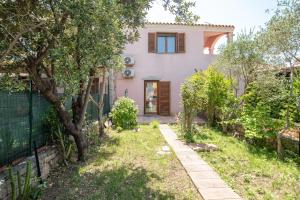 a house with a garden and a fence at Sardegna Budoni giardino e Jacuzzi in Budoni