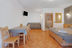 a room with a bed and a table and a couch at Agritur Sotto il Melo in Caldes