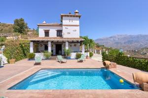a villa with a swimming pool in front of a house at Casa Miraflores in Arenas