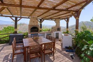a wooden deck with a table and a pizza oven at Casa Miraflores in Arenas