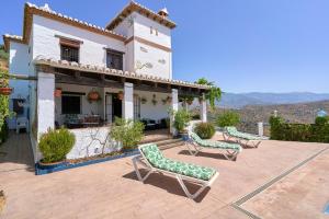 a house with two lawn chairs on a patio at Casa Miraflores in Arenas