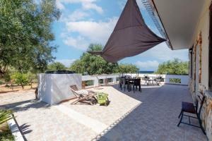 a patio with an umbrella and a table and chairs at Il Giglio Rosa in Sorso