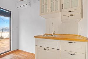 a kitchen with white cabinets and a sink at Ca Xotxim in Altea +19 photos