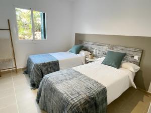 a bedroom with two beds and a window at Casa da Lúa in Sant Lluis