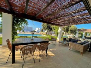 a patio with a table and chairs under a pergola at Casa da Lúa in Sant Lluis