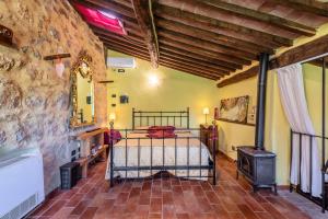 a bedroom with a bed and a wood stove at Agriturismo Podere Marroneto in Monticiano