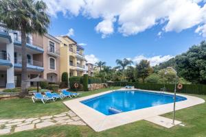a swimming pool in a yard next to a building at Beautiful penthouse with solarium in Benahavís