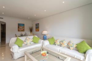 a living room with two white couches with green pillows at Beautiful penthouse with solarium in Benahavís +18 photos
