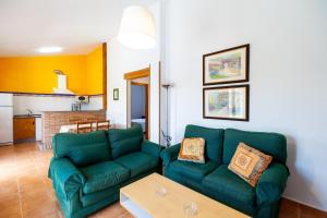 a living room with a green couch and a table at Luisa 2 in Conil de la Frontera