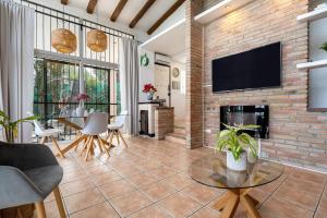 a living room with a brick fireplace and a tv at Valle de los sueños in Canyelles