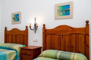 two beds in a room with white walls at Luisa 2 in Conil de la Frontera +18 photos